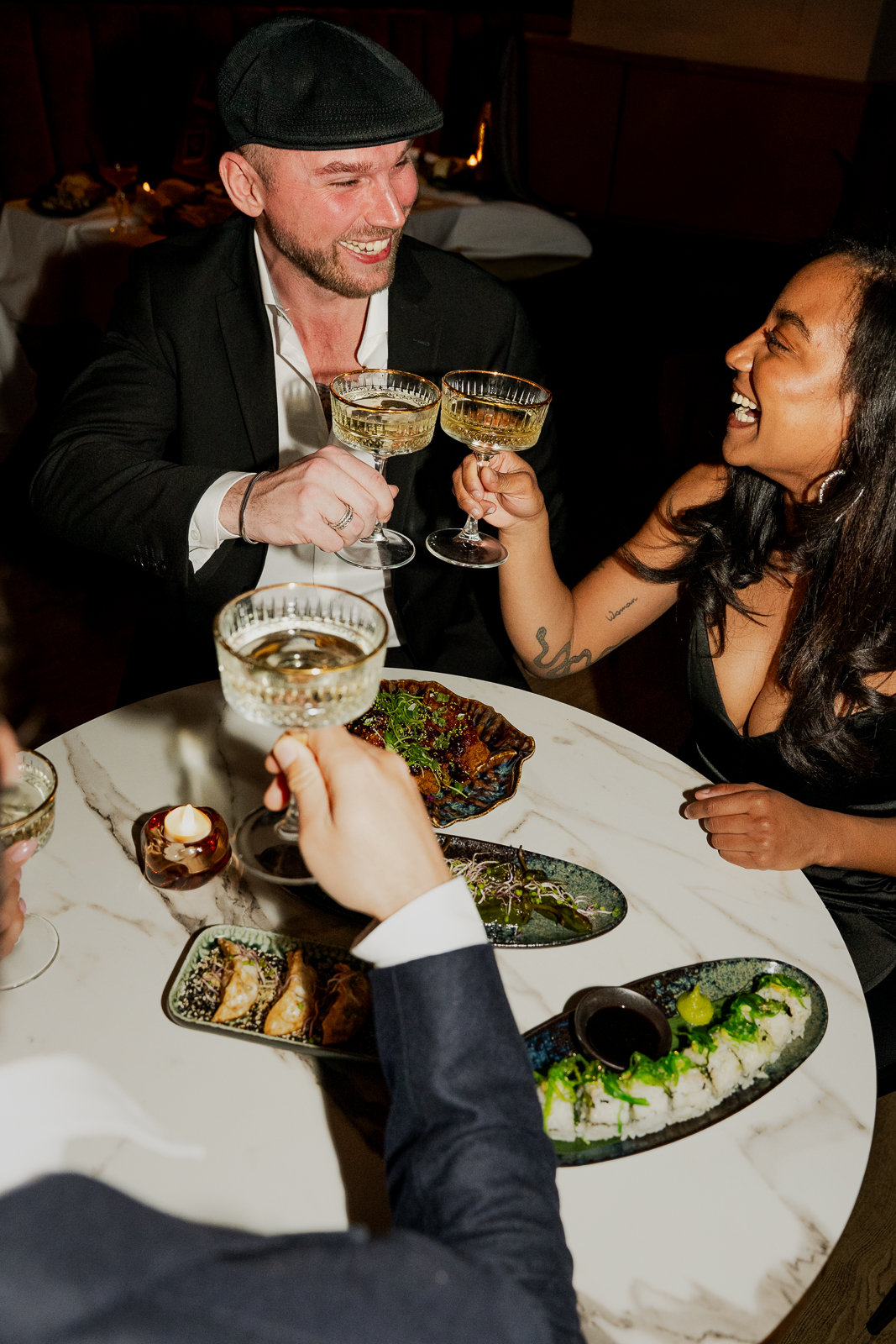 Gasten proosten met coupes champagne aan tafel met hapjes